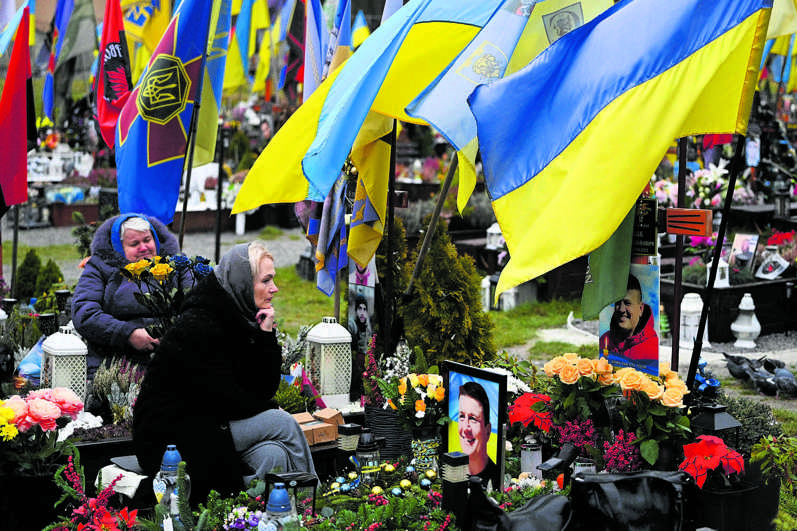  Mensen rouwen in Lviv bij de graven van Oekraïense militairen op de begraafplaats van Lychakiv op de Dag van de Oekraïense Strijdkrachten. foto: AFP 