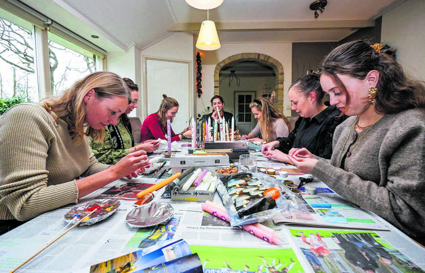   Anna van der Bos, Liesbeth van der Bos, Martine van der Weij, Pietrijna Ruinia, Karin Visser, Wilma van der Bos en Marjanna Rienstra (vlnr) zijn druk bezig met het beschilderen van kaarsen waarvan de opbrengst naar een goed doel gaat.  Foto: Marco Keyzer