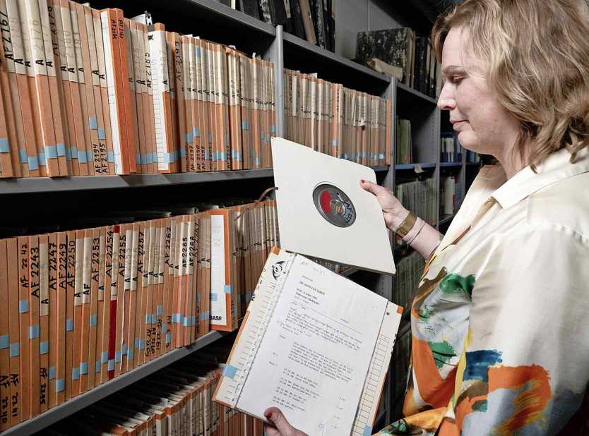  Omrop Fryslân-archivaris Saapke Binnema grasduint door het archief: ‘Moai om wat yn ’e hannen hâlde te kinnen.’  foto: Hoge Noorden/Jaap Schaaf 